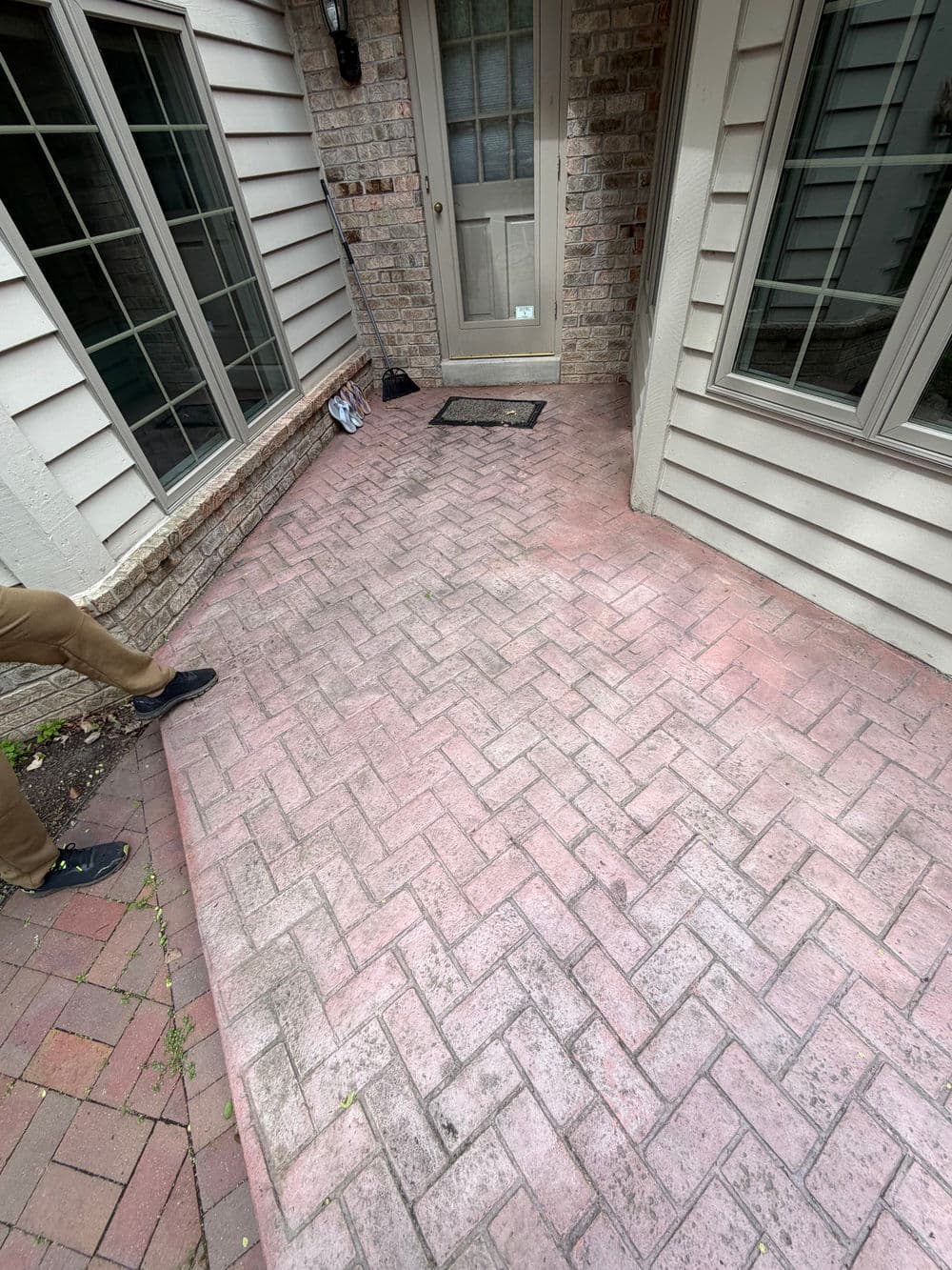 Paver walkway leading to a door, showcasing a clean entrance with adjacent brickwork.